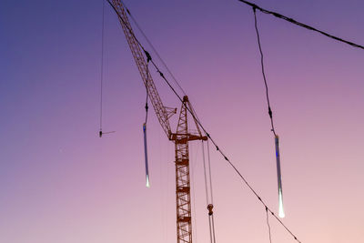 Low angle view of crane against clear sky