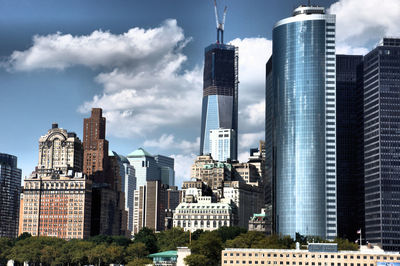 Buildings in city against cloudy sky