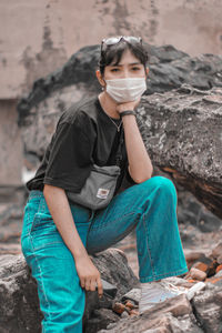 Portrait of young man sitting on rock