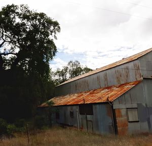 Abandoned house on field against sky