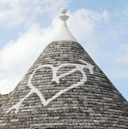 Low angle view of text on building against sky