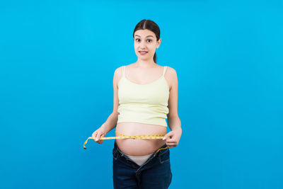 Portrait of a beautiful young woman against blue background