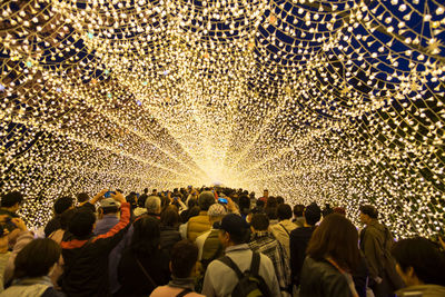 People walking below illuminated lighting decoration