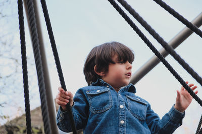 Portrait of young child swinging at playground