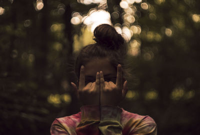 Close-up of teenage girl gesturing during sunset