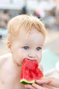 Close-up portrait of boy eating fruit