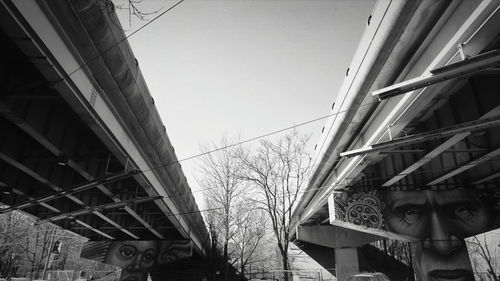 Low angle view of bridge and buildings against sky