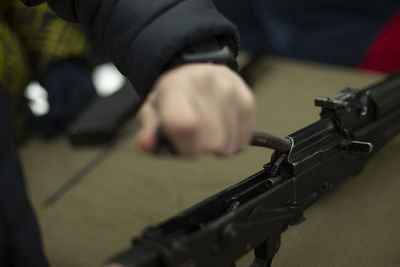 Midsection of man holding gun