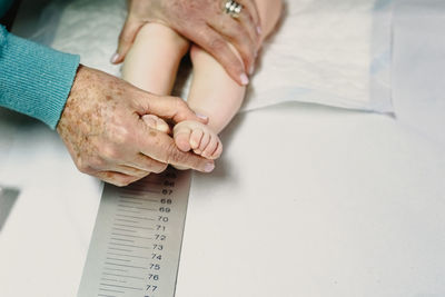 High angle view of hands on bed