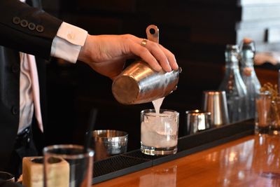 Close-up of hand pouring wine in glass