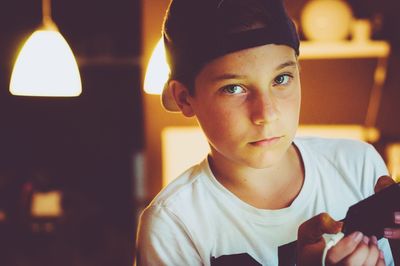 Close-up portrait of boy holding smart phone