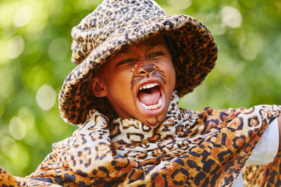 Close-up of boy imitating leopard in yard