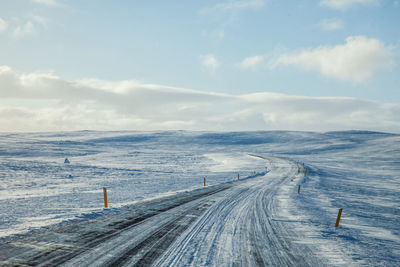 Scenic view of snow covered road against sky