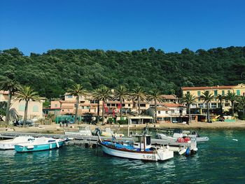 Boats moored in river against clear sky