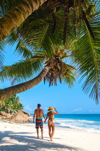 Rear view of woman walking on beach