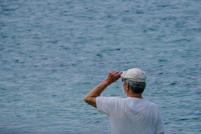 Rear view of man standing in sea