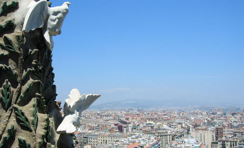 Aerial view of city buildings against clear blue sky