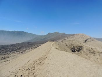 Scenic view of desert against blue sky