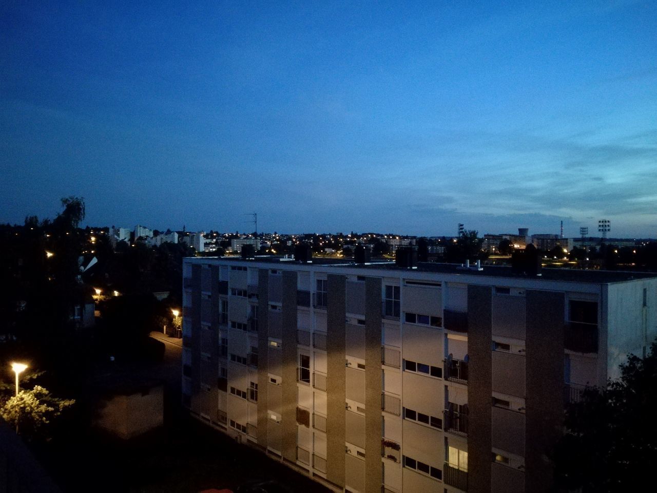 ILLUMINATED CITYSCAPE AGAINST BLUE SKY