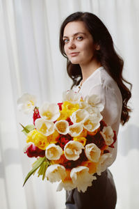 Portrait of young woman holding bouquet