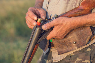 Hunter man in camouflage with a gun during the hunt in search of wild birds or game.