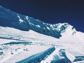 Scenic view of snowcapped mountains against blue sky