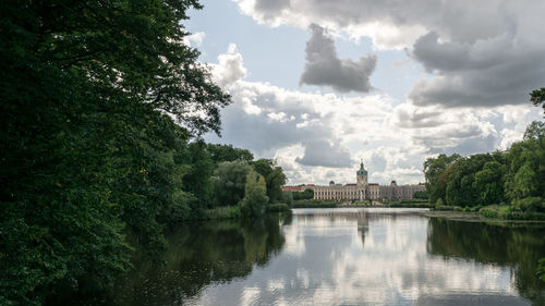 Scenic view of river by trees against sky