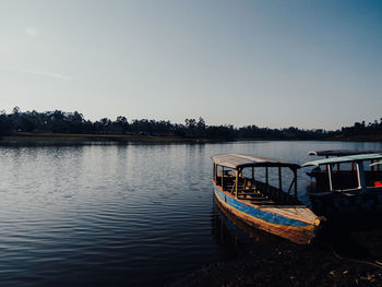 Boat moored in lake against sky