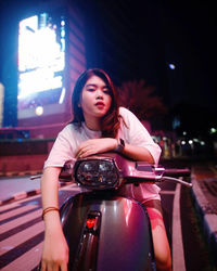 Beautiful young woman sitting in car at night