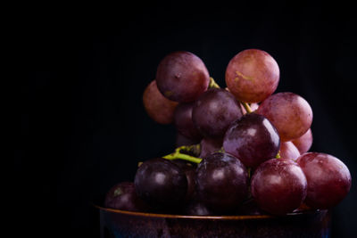 Close-up of red grapes against black background