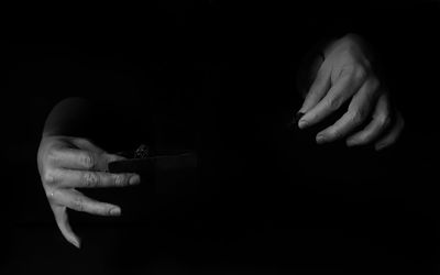 Cropped image of hand holding over black background