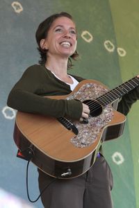 Portrait of a smiling young woman playing guitar