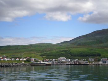 Scenic view of river and mountains against sky