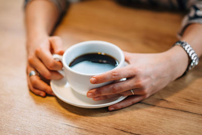 Midsection of woman holding coffee maker