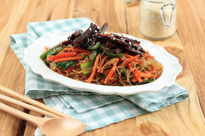 Korean food, stir fried beef and glass noodles with vegetable japchae. topped with sesame seed