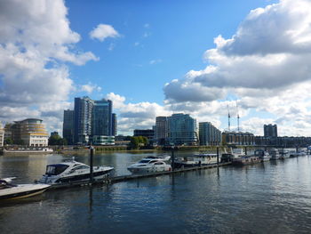 City buildings by river against sky