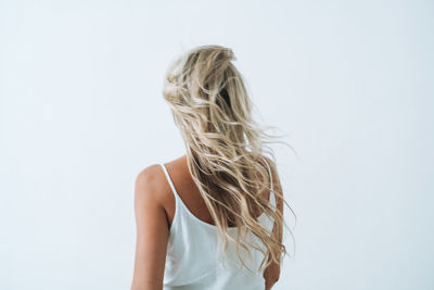 Rear view of woman standing against white background