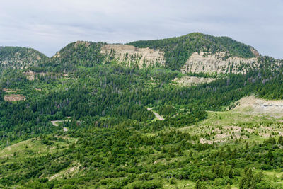 Scenic view of green landscape and mountains against sky