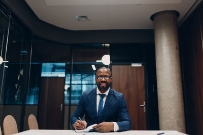 Portrait of young man standing in office