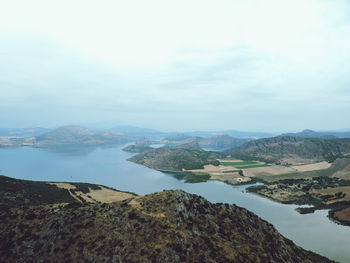 Scenic view of sea and mountains against sky