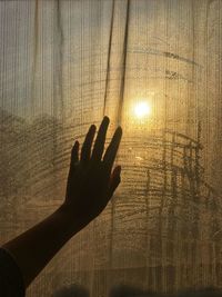 Person hand touching sun