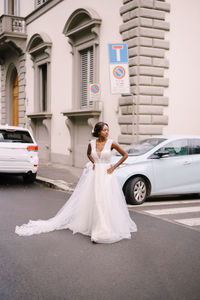 Full length of bride standing on road against building