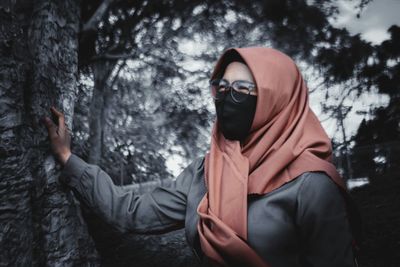 Portrait of female friends in snow covered tree