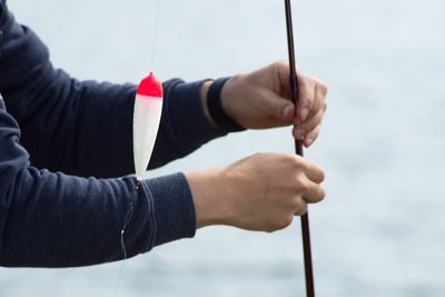 Cropped hands of woman fishing outdoors