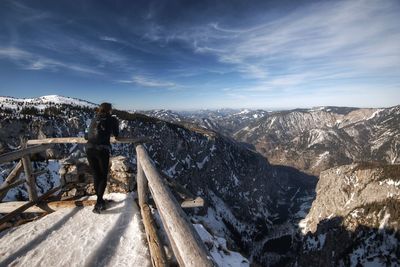 Man standing on snowcapped mountain against sky