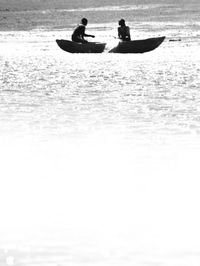 Silhouette people in boat on sea