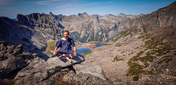 Young man sitting on rock