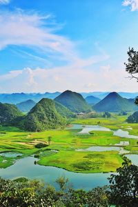 Scenic view of field and mountains against sky