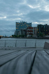 Road by buildings against sky in city