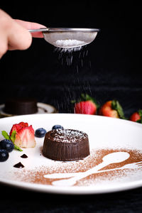 Midsection of person preparing cake